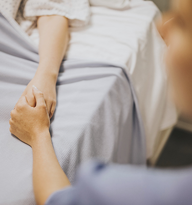 Nurse holding the hand of a patient